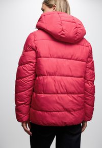 Czerwona kurtka puchowa z kapturem, z pikowanym teksturem i elastycznymi mankietami. Z tyłu ma gładkie wykończenie oraz regulowaną talię.