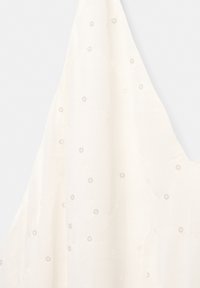 Il tessuto bianco presenta sottili abbellimenti circolari e una texture leggera e trasparente. Il design è drappeggiato, creando morbide pieghe.