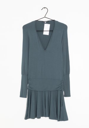 Tyrkis langærmet kjole med dyb V-udskæring, samlet talje og bred skørt. Lavet af blødt stof; har et mærke fastgjort ved halsudskæringen.