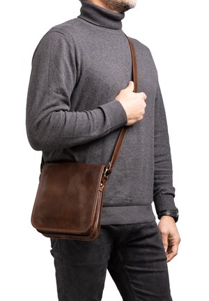 Borsa a tracolla in pelle marrone con una texture liscia, forma rettangolare, tracolla e dettagli di cucitura sottili. Adatta per l'uso quotidiano.