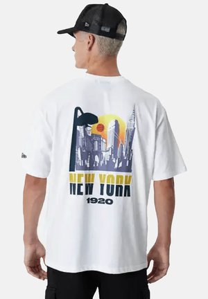 Witte t-shirt met korte mouwen, voorzien van een grafische afbeelding van de skyline van New York in paars en geel, met een zon en een basketbal. Gemaakt van katoen, met een ontspannen pasvorm.