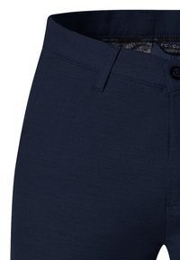 Marineblauwe tapered broek met een soepele textuur, een platte voorkant, knoopsluiting en riemlussen. De binnenkant heeft een gemarmerde voering.