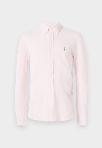 Svetlo roza srajca s dolgimi rokavi in gumbi, z gumbastim ovratnikom in majhnim vezenim logotipom na levem prsnem delu.