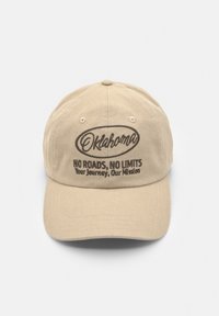 Cappello in cotone beige con ricamo: "Oklahoma" e "NESSUNA STRADA, NESSUN LIMITE. Il tuo viaggio, la nostra missione." Design strutturato e visiera curva.