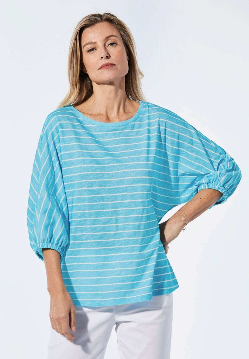 Helles, blau gestreiftes Oberteil mit lockerer Passform, weitem Ausschnitt und puffartigen Ärmeln. Hergestellt aus weichem Stoff mit horizontalen weißen Streifen.