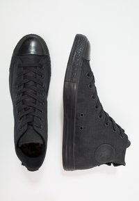 Le sneakers alte in tela nera presentano una punta in gomma, una superficie testurizzata e occhielli tono su tono. Include una suola in gomma nera testurizzata.