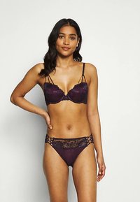 Spitze-Unterwäsche-Set in Tiefpurpur mit einem gepolsterten BH mit verstellbaren Trägern und passendem Bikini mit filigranen Spitzendetails.