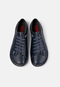 Marineblauwe leren schoenen met een gladde textuur, voorzien van zes veterogen en een ronde neus. Van binnen is er rode branding op de binnenzool.