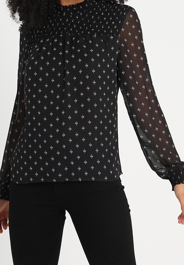 Blusa nera a maniche lunghe con scollatura arricciata, tessuto trasparente e motivo a diamante argentato. I polsini presentano dettagli elasticizzati per una vestibilità ottimale.