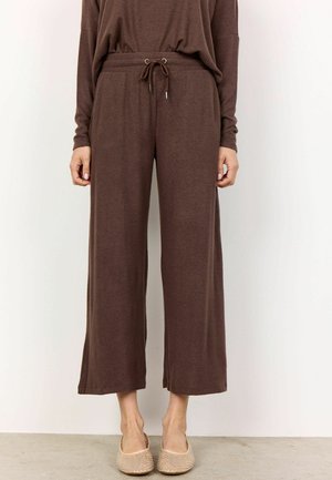 Bruine wijdvallende broek met een trekkoord in de taille en ribbelstructuur. Ze hebben zijopeningen voor meer bewegingsvrijheid en een ontspannen pasvorm.