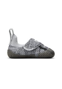 Zapato slip-on de punto en gris y negro con suela de goma texturizada, que presenta una correa de tela con cierre de gancho y bucle y una lengüeta en el talón.