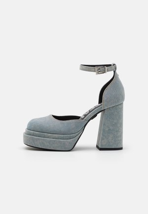 Denim plateau schoenen, lichtblauwe kleur, ronde neus, hoge blokhak, verstelbare enkelriem, contrasterende zwarte zool, textuurstof.