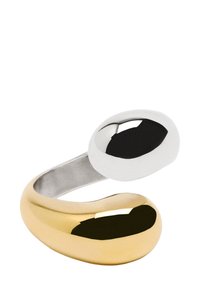 Metalowy pierścionek o złotym i srebrnym wykończeniu, z organicznym, falującym kształtem i wypolerowaną powierzchnią. Charakteryzuje się asymetrycznym, rzeźbiarskim designem.