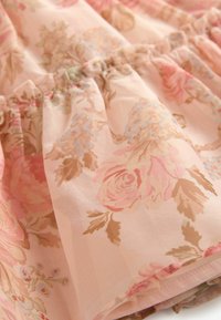 Blumiger Baumwollstoff in sanften Rosa- und Beigetönen zeigt Rosen und blaue Blumen, präsentiert in einem gerafften Design mit transparenter Textur.