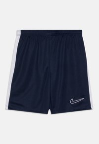 Pantalones cortos deportivos azul marino con franjas blancas laterales, cintura elástica y logo blanco de Nike en el lado derecho frontal, textura de tela suave.