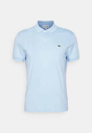 Polo-shirt bleu clair en coton, avec un col classique, des manches courtes et un petit logo Lacoste noir sur le côté gauche.