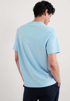 Svetle modré bavlněné tričko s krátkými rukávy a kulatým výstřihem, se hladkým povrchem a standardním střihem. Design zobrazuje zadní pohled.