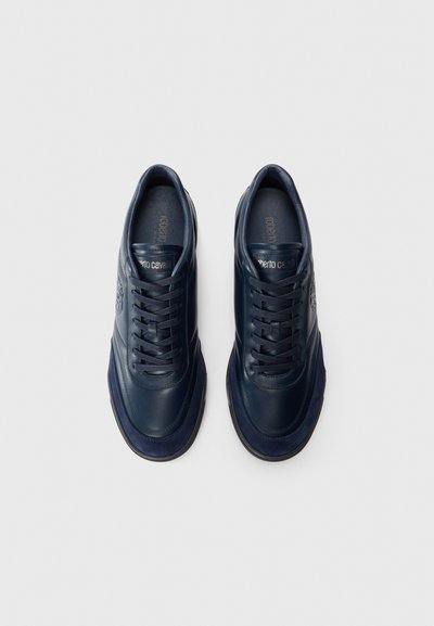 O pereche de sneakers din piele albastru închis cu șireturi și logo-uri embossate pe lateral, așezate pe un fundal alb simplu.