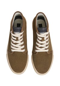 Rudi dirbtinės odos sportbačiai su smėlio spalvos raišteliais ir balta guma, turintys siūtą dizainą ir prekės ženklo etiketę ant liežuvėlio.