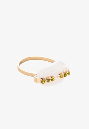 Goldener Ring mit einem weißen Stein als Mittelpunkt und drei eingearbeiteten grünen Steinen entlang des Rings; glatte Textur und abgerundetes Design.