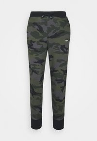 Zelené maskáčové tepláky s černým pasem, stahovací šňůrkou a žebrovanými manžetami. Na levém boku je malý logo Nike.