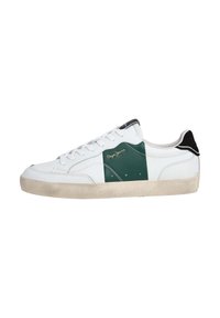 White sneaker with green suede detail, black accents on the heel, white laces, and textured rubber sole. Gold logo on the side.