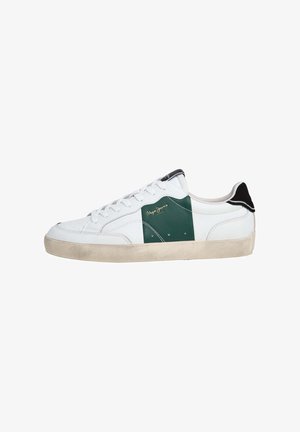 Witte sneaker met groene suède details, zwarte accenten op de hiel, witte veters en een gestructureerde rubberen zool. Gouden logo aan de zijkant.