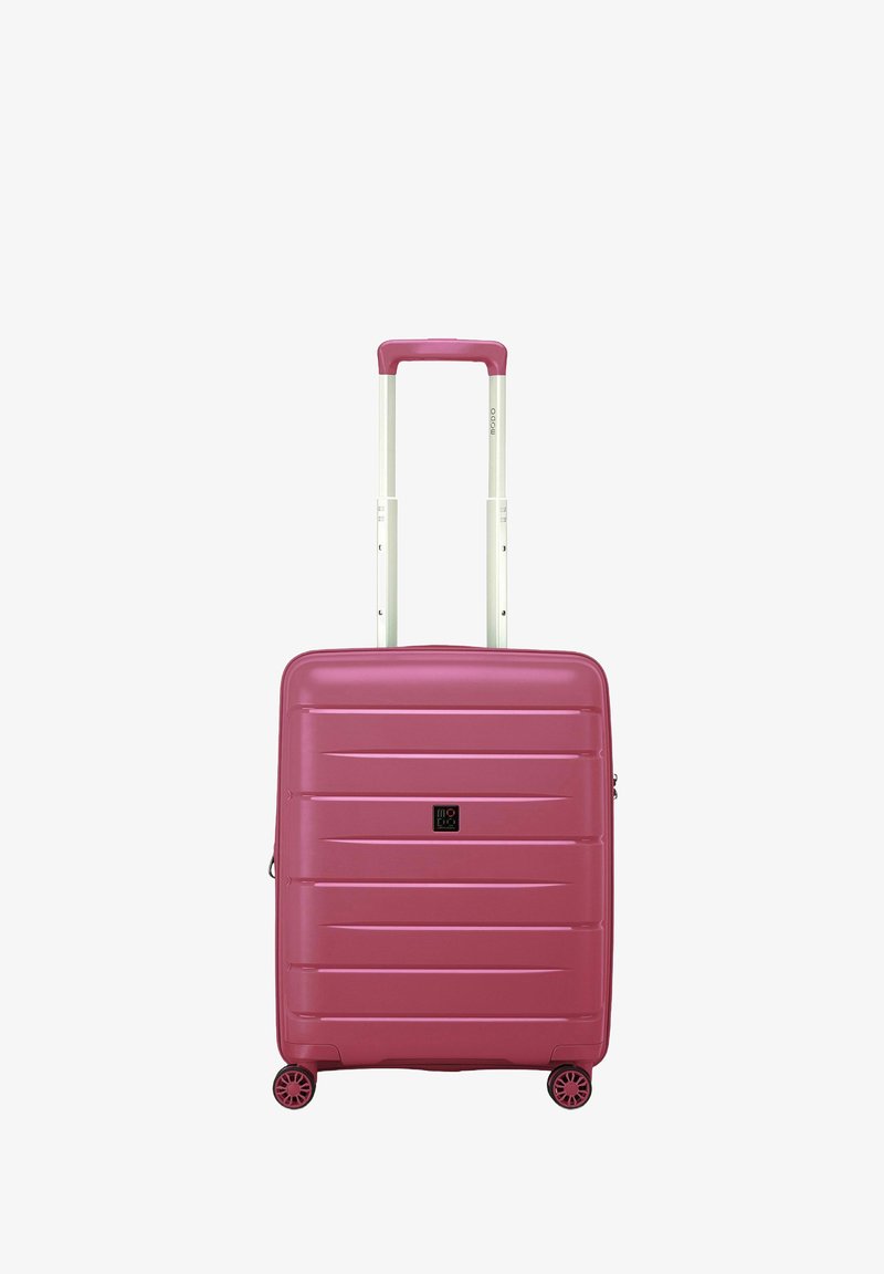Valigia rigida rosa con scanalature orizzontali, manico bianco estraibile e quattro ruote girevoli per una facile manovrabilità.