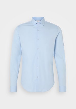 Hellblaues Langarm-Hemd mit klassischem Kragen, abgerundetem Saum und perlenbesetzten Knöpfen. Aus glattem Baumwollstoff, taillierte Passform.