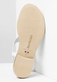 Sole di sandalo bianca con grip testurizzato, marchiata "NeroGiardini," e taglia "37." Prodotto in Italia, presenta un colore beige chiaro e una finitura liscia.