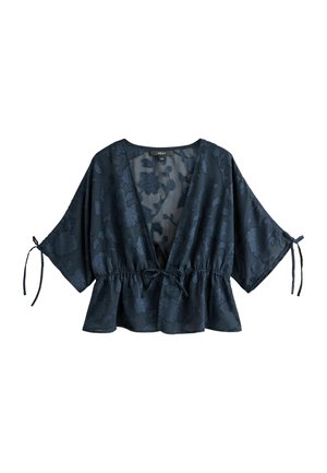 Dark blue floral jacquard blouse with deep V-neck, wide sleeves tied at cuffs, cinched waist, and peplum hem.