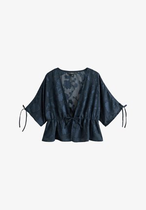 Tumesinist lillemustriga džakaarpluus sügava V-kaelusega, laiade varrukatega, mis on mansettide juures seotud, vöökoht pingul ning peplumäärega.