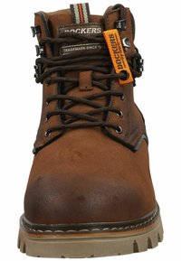 Bota de senderismo de cuero marrón con ojales de metal, superficie texturizada, collar acolchado y etiqueta naranja en contraste. Suela de goma robusta con tracción.