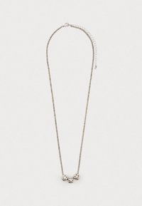 Srebrny naszyjnik łańcuszkowy z trzema koralikami w kształcie uśmiechniętych twarzy, równomiernie rozmieszczonymi na środku, na tle gładkiego, jasnego tła.