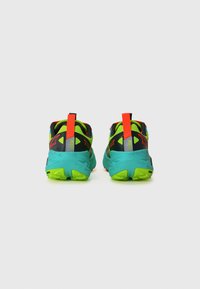 Multikleurige sportschoenen met een zwarte mesh bovenkant, levendige groene en blauwe accenten, gedurfde oranje details en een gestructureerde rubberen zool.