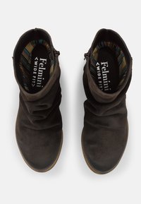 Botines de ante marrón con detalle de recogido, de corte ancho y con un forro de rayas de colores. Con cierre lateral para facilitar su uso.