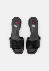 Black leather slide sandals featuring a woven strap design. Flat sole with a smooth texture and brand logo placed centrally on the insole.