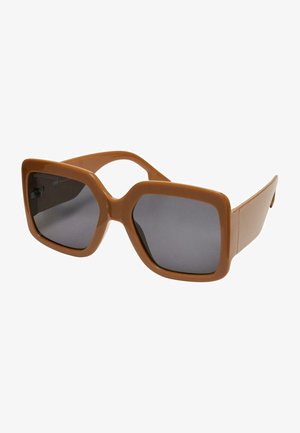 Ruske oversized sunčane naočale s debelim plastičnim okvirom, tamnim lećama i geometrijskim dizajnom. Glatka površina i široke tempere.