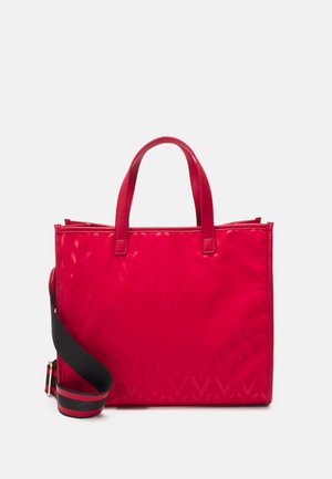 Red tote bag with a geometric pattern, featuring two short handles and a longer black strap. Glossy finish, zip closure at the top.