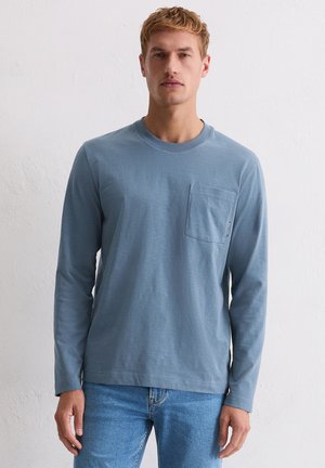 Langärmeliges, hellblaues Baumwollhemd mit Rundhalsausschnitt und Brusttasche. Verfügt über eine lockere Passform und eine weiche, glatte Textur.