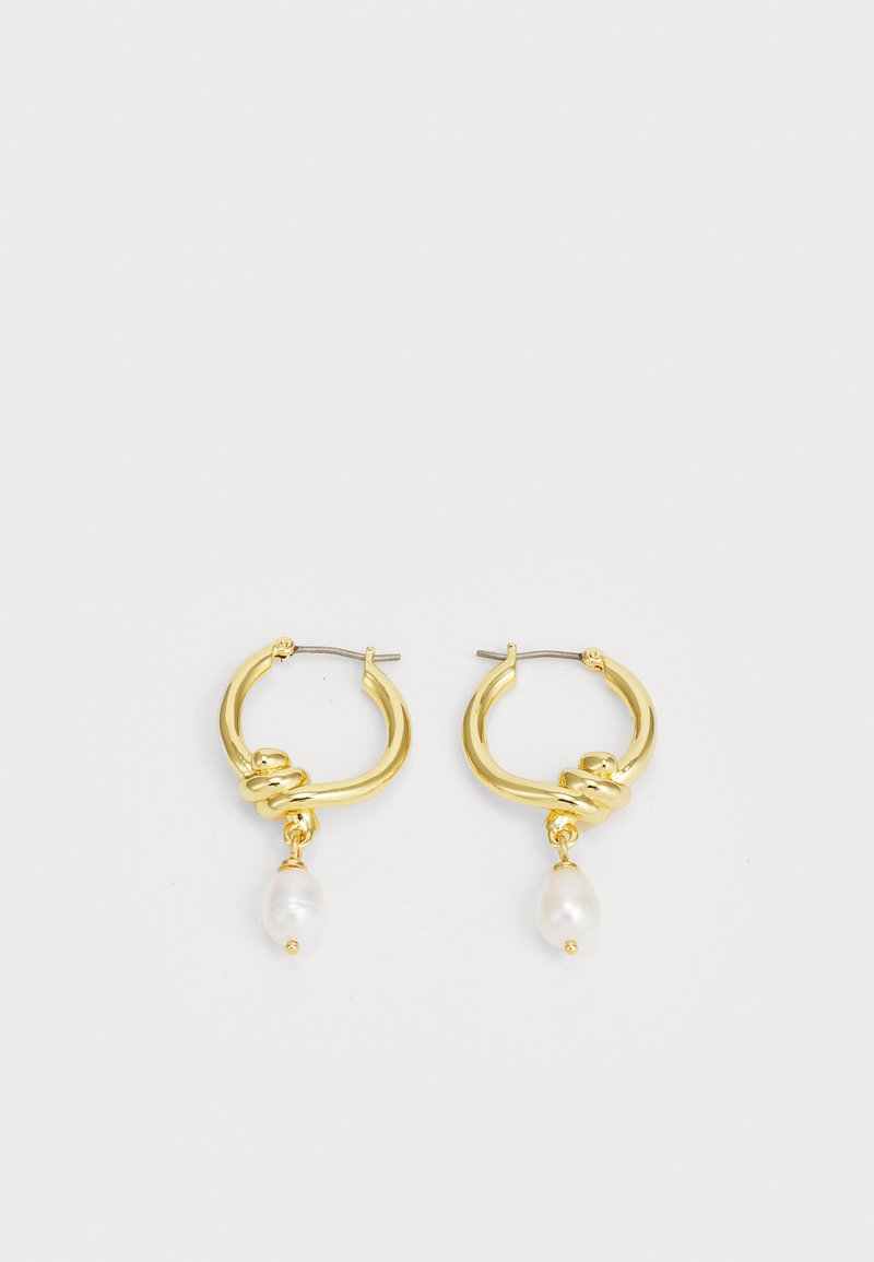 Aukso auskarai, turintys susuktą dizainą, akcentuoti lašo formos baltais perlais. Sidabriniai elementai saugiai sujungia komponentus.