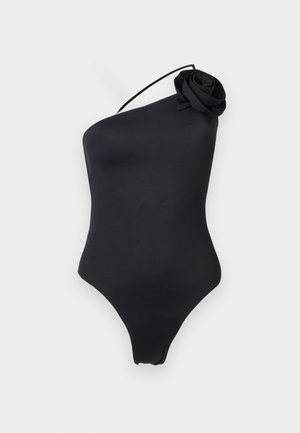 Zwart badpak met één schouder, dun bandje en stoffen roos detail op de schouder, weergegeven op een effen lichte achtergrond.