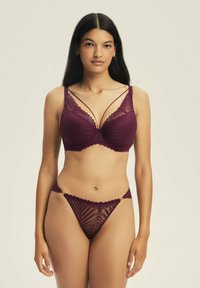 Burgundowa koronkowa braletka z falbaniastymi krawędziami i podwójnym paskiem, połączona z pasującym stringami z geometrycznym wzorem i złotymi elementami.