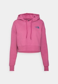 Sudadera corta con capucha de tejido de algodón en color rosa brillante. Cuenta con capucha ajustable con cordón, mangas largas y un logo azul en el pecho izquierdo. Textura suave en general.