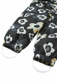 Water-resistant black snowsuit with large floral pattern in cream, gray, and yellow. Elastic cuffs and straps at the wrists for secure fit.