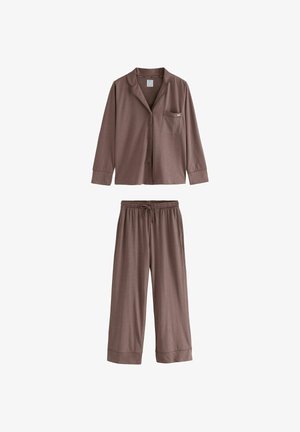 Kärry-pyjama setti ruskeasta puuvillasta, joka sisältää napitettavan paidan, jossa on tasku, sekä joustavat housut, jotka ovat löysäpohjaiset. Pehmeä rakenne ja yksinkertainen muotoilu.