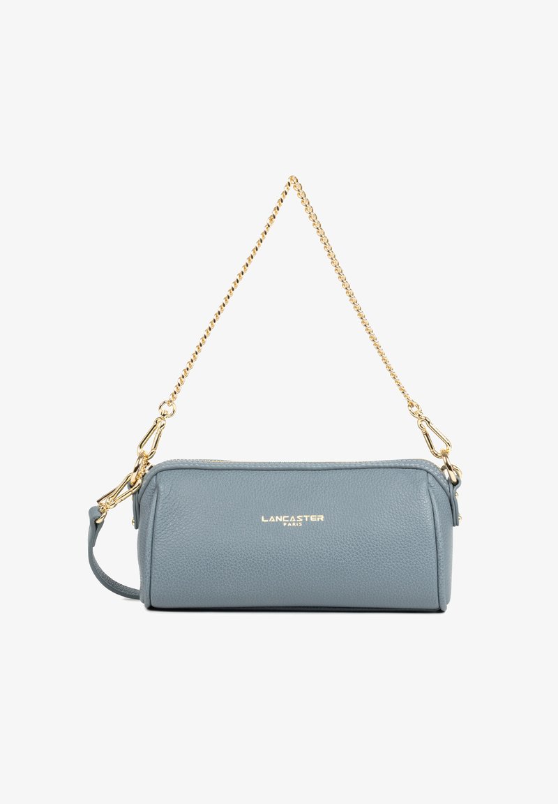 Sac à main en cuir bleu clair avec une chaîne en or. Fermeture zippée et logo subtil embossé à l'avant. Forme cylindrique compacte.