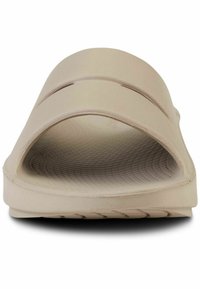 Beige slide sandal with two wide upper straps, textured footbed, and a lightweight design. Rounded shape with open toe and side cutouts.