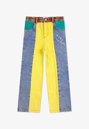 Pantalon en denim avec des jambes larges rayées de bleu, jaune et vert. Comprend une taille brune et un logo blanc sur le devant.