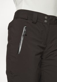 Černé, voděodolné kalhoty se hladkým povrchem, slim fit, s kapsou na zip a dvěma patentkami v pase.